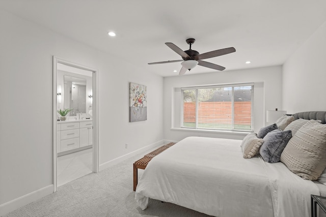 carpeted bedroom with ensuite bathroom, ceiling fan, and sink