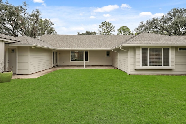 rear view of property featuring a lawn