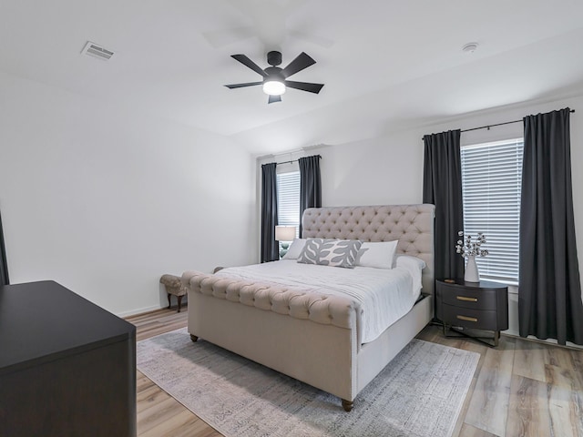 bedroom featuring ceiling fan, lofted ceiling, and light hardwood / wood-style flooring