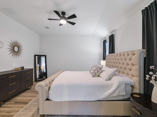 bedroom with ceiling fan, light wood-type flooring, and vaulted ceiling