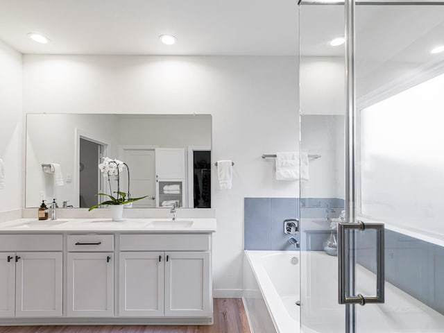 bathroom featuring hardwood / wood-style floors, vanity, and a bath