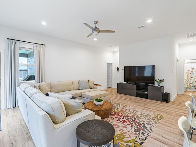 living room with ceiling fan and light hardwood / wood-style flooring