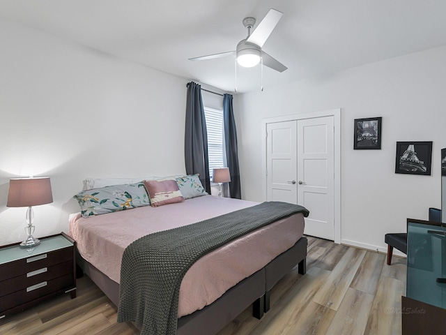 bedroom featuring ceiling fan, a closet, and light wood-type flooring