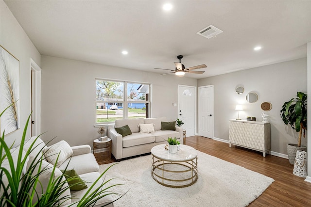 living room with dark wood-type flooring and ceiling fan