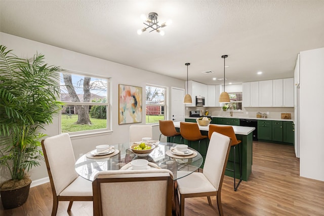 dining room featuring a textured ceiling and light hardwood / wood-style floors