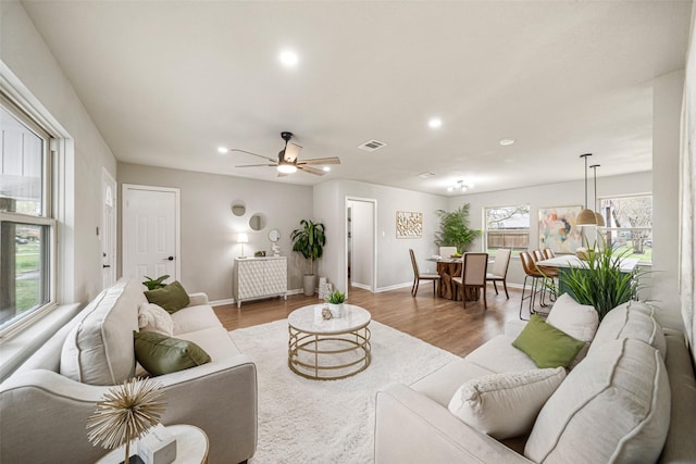 living room with ceiling fan and light wood-type flooring