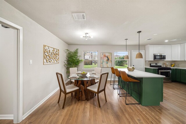 dining room featuring light hardwood / wood-style floors and a textured ceiling