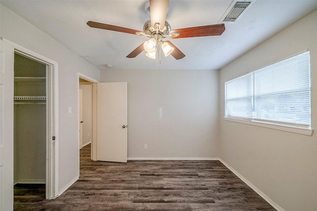 unfurnished bedroom with ceiling fan, dark hardwood / wood-style floors, and a closet