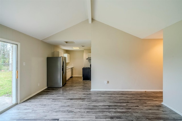 unfurnished living room featuring wood-type flooring and lofted ceiling with beams