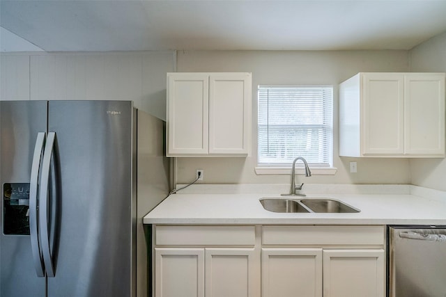 kitchen featuring stainless steel appliances, white cabinetry, and sink