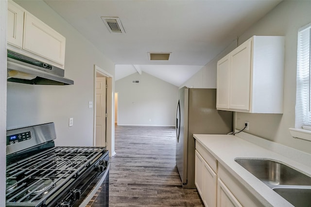 kitchen featuring vaulted ceiling, appliances with stainless steel finishes, white cabinetry, and hardwood / wood-style floors