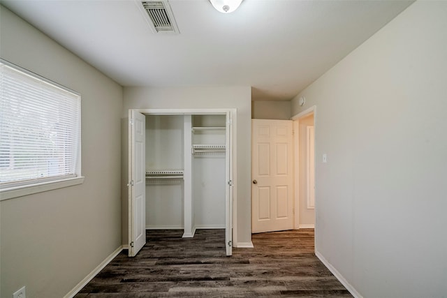 unfurnished bedroom featuring a closet and dark hardwood / wood-style floors