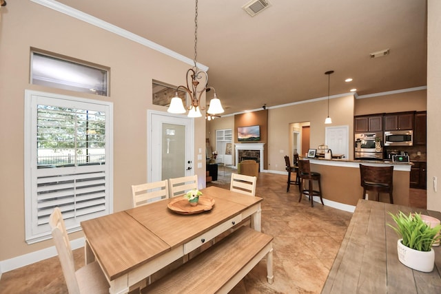 dining area with crown molding and a chandelier