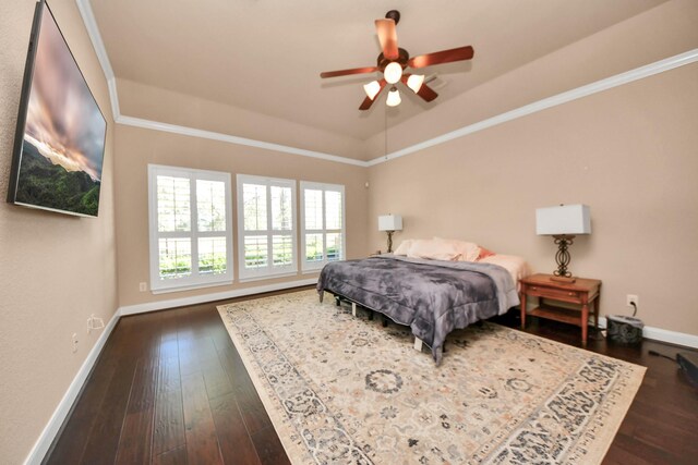 bedroom featuring dark hardwood / wood-style flooring, ornamental molding, ceiling fan, and a tray ceiling