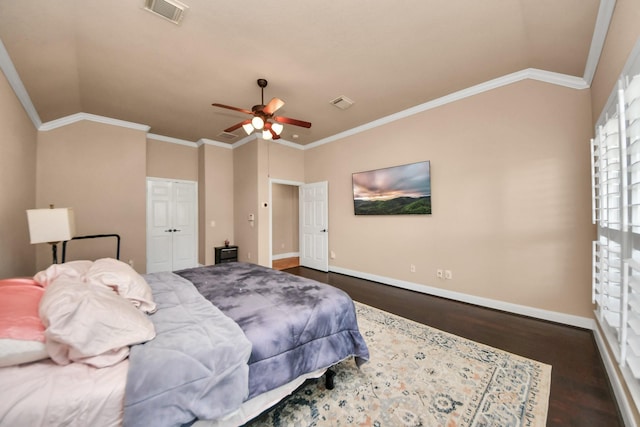 bedroom with crown molding, dark wood-type flooring, ceiling fan, vaulted ceiling, and a closet