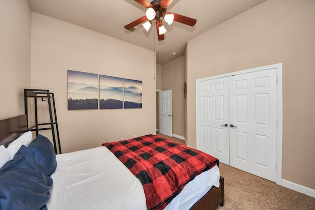 carpeted bedroom with ceiling fan, lofted ceiling, and a closet