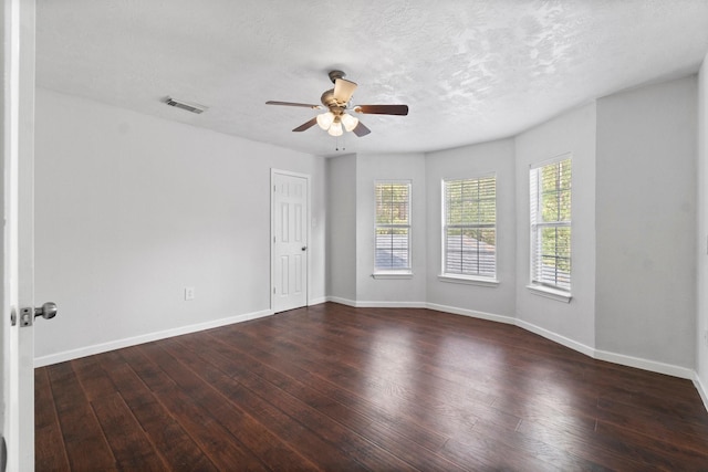 empty room featuring a textured ceiling, ceiling fan, and dark wood-type flooring