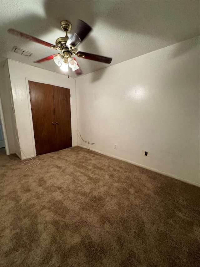 unfurnished bedroom featuring ceiling fan, a closet, carpet, and a textured ceiling