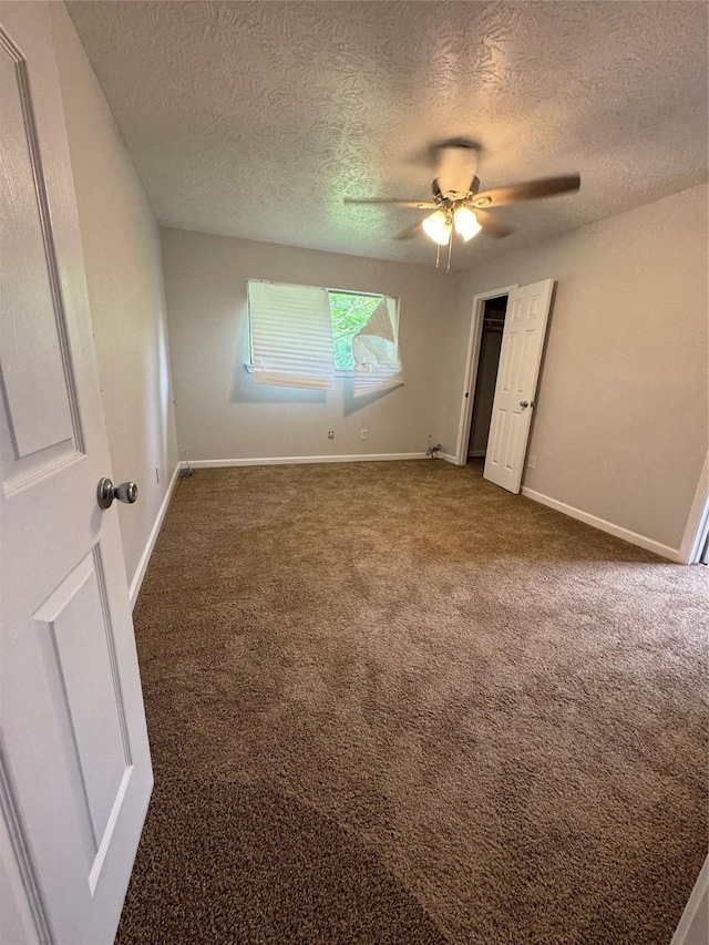 unfurnished room with ceiling fan, carpet floors, and a textured ceiling