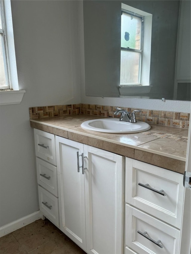 bathroom featuring a wealth of natural light, tile patterned flooring, and vanity