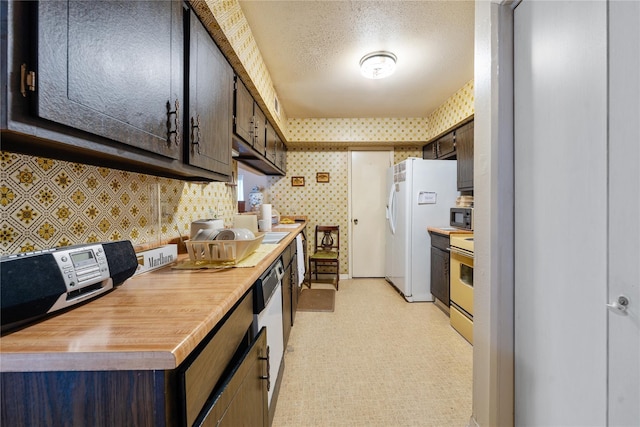 kitchen with butcher block countertops, dark brown cabinetry, white refrigerator with ice dispenser, and range with electric cooktop