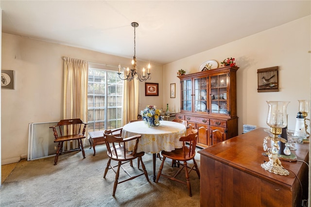 dining room with carpet floors and an inviting chandelier