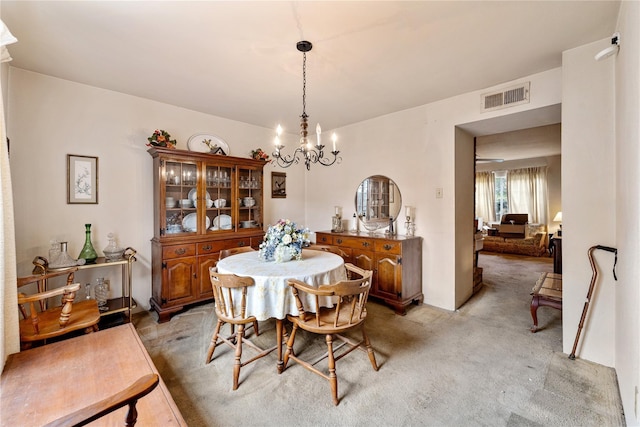 dining space featuring light carpet and ceiling fan with notable chandelier