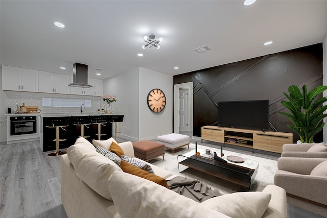 living room featuring light hardwood / wood-style flooring and sink