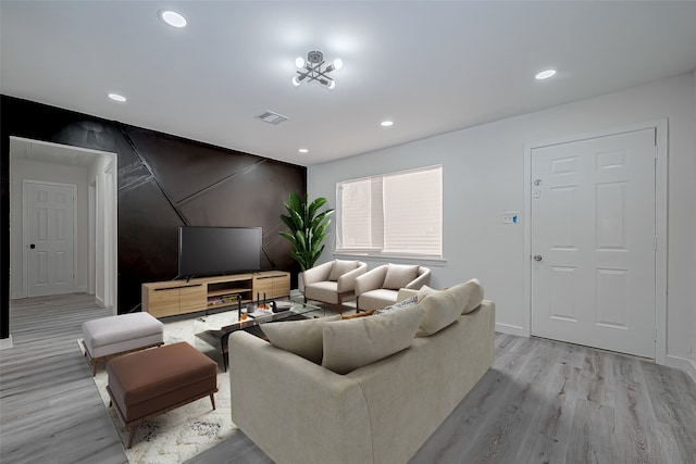 living room featuring a chandelier and light hardwood / wood-style flooring