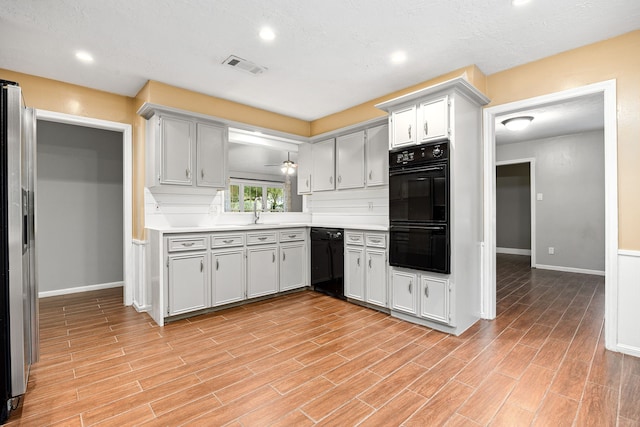 kitchen with ceiling fan, sink, tasteful backsplash, a textured ceiling, and black appliances