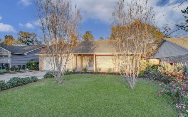 view of front of home with a garage and a front lawn