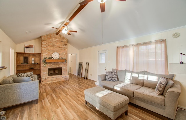 living room featuring a brick fireplace, ceiling fan, lofted ceiling with beams, and light wood-type flooring