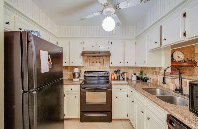 kitchen with black appliances, light stone counters, white cabinetry, and sink