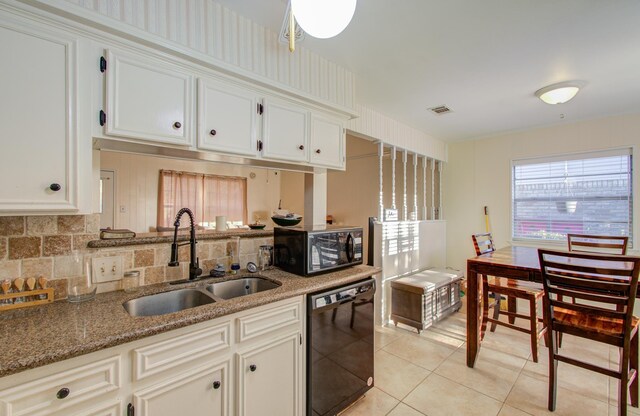 kitchen with white cabinetry, light stone countertops, sink, light tile patterned floors, and black appliances