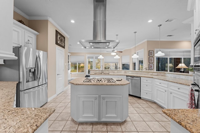 kitchen featuring island exhaust hood, appliances with stainless steel finishes, white cabinets, and pendant lighting