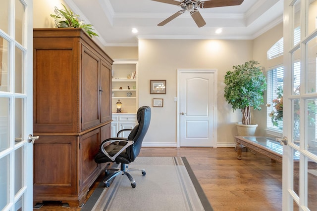 office space with french doors, light wood-type flooring, ornamental molding, a tray ceiling, and ceiling fan