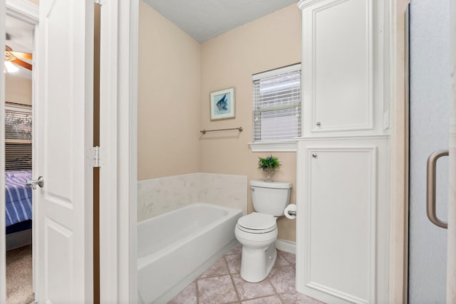 bathroom featuring a bath, a textured ceiling, toilet, and tile patterned floors