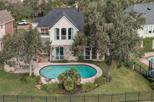 view of pool with a lawn and a patio