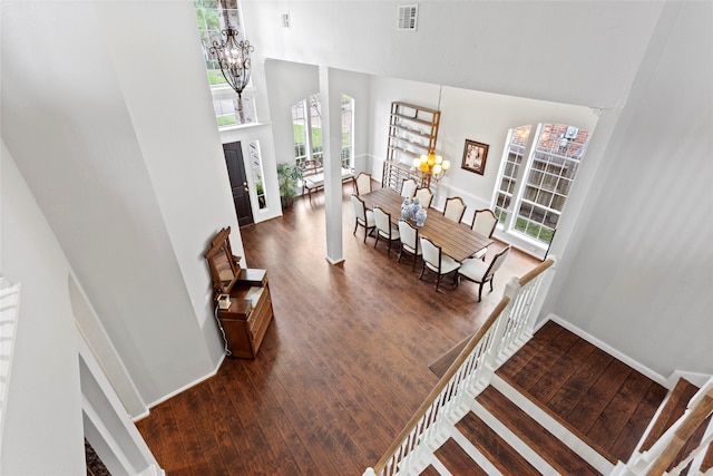 interior space with a towering ceiling, hardwood / wood-style flooring, and a notable chandelier