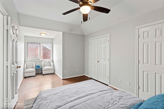 bedroom featuring hardwood / wood-style floors, ceiling fan, and lofted ceiling