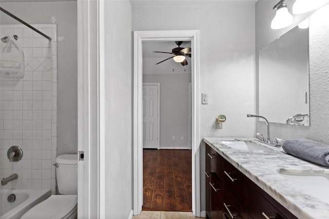 full bathroom with ceiling fan, tiled shower / bath combo, toilet, vanity, and hardwood / wood-style flooring