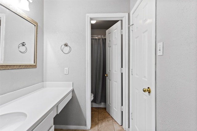 bathroom with tile patterned flooring, vanity, and toilet