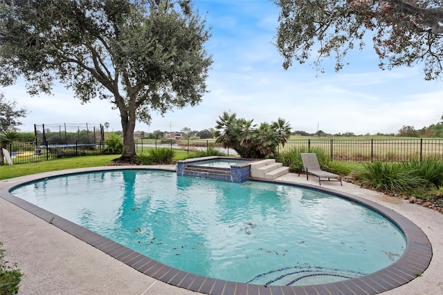 view of pool featuring a trampoline and an in ground hot tub