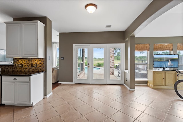 entryway with light tile patterned floors and french doors