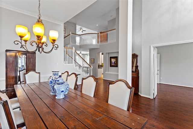 dining space featuring dark hardwood / wood-style flooring, ceiling fan with notable chandelier, ornamental molding, and a high ceiling