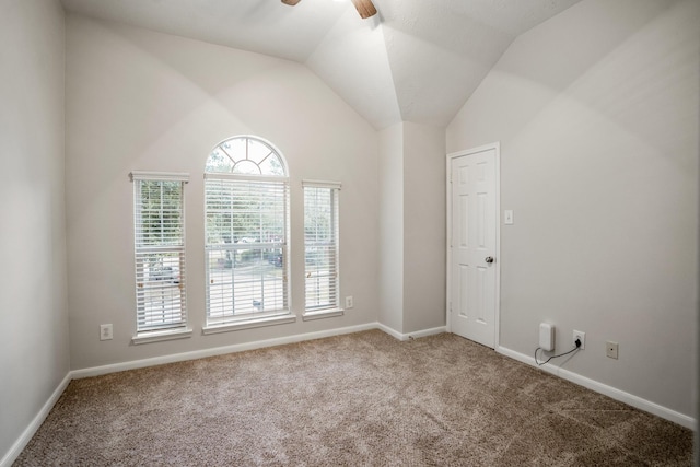 spare room featuring vaulted ceiling, ceiling fan, and carpet flooring