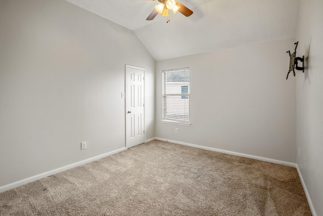 carpeted spare room with lofted ceiling and ceiling fan