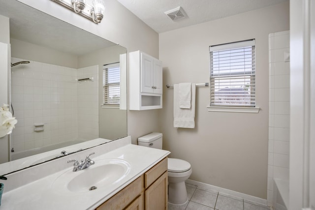 full bathroom with vanity, a textured ceiling, tile patterned floors, toilet, and tiled shower / bath