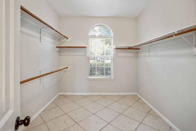 walk in closet with light tile patterned floors