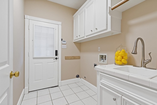 clothes washing area with cabinets, washer hookup, hookup for an electric dryer, sink, and light tile patterned floors